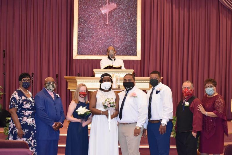 Wearing masks for photos after the small ceremony are (l-r) mother of the bride Tynice Duffie, father of the bride Daryl Duffie, matron of honor Brooke Talbot, Bishop Arthur D. Jones, Kayla Harmon, Jevon Harmon, best man Trey Bowden, father of the groom Clarence Harmon and mother of the groom Chanteea Harmon.